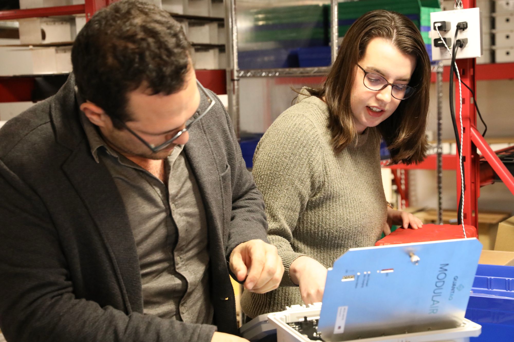 QuantAQ Hardware Engineer Abigail Fry and CEO David Hagan investigate a device sent in to our Somerville, MA lab for repairs.